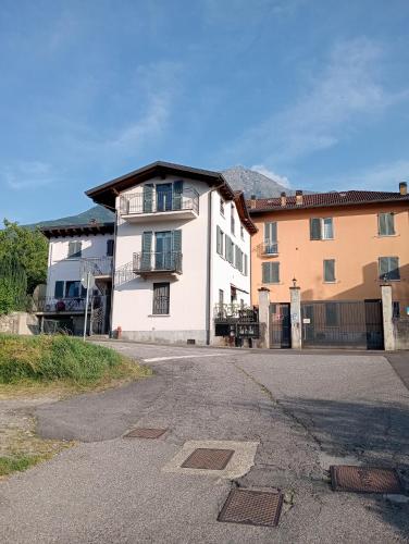 a white house with a balcony on a street at Appartamento Bonita Vista in Colico