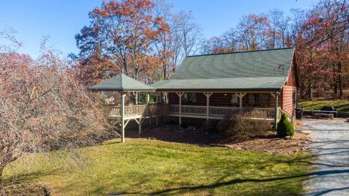 a small red house with a porch in the grass at A Bears Hill in Boone