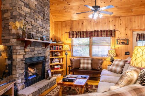 a living room with a stone fireplace and a couch at A Bears Hill in Boone