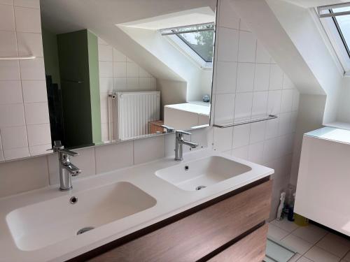 a bathroom with two sinks and a mirror at Selma hosts Tomorrowland 2026 in Duffel