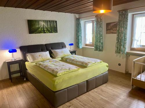 a bedroom with a large bed with yellow sheets at Weissenhof | Chiemgau Karte in Rottau
