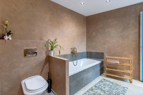 a bathroom with a bath tub and a toilet at Trasorka House in Veli Lošinj