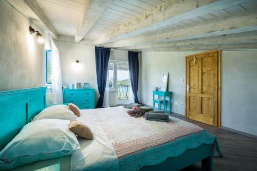 a bedroom with a large bed with a blue headboard at Trasorka House in Veli Lošinj