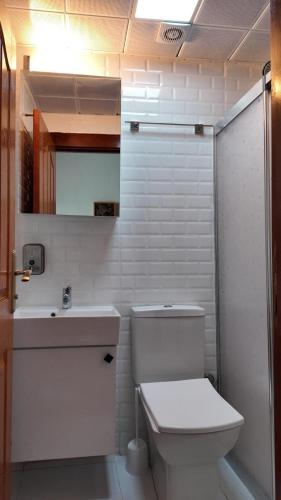 a white bathroom with a toilet and a sink at Gaziayintap Konağı in Şahinbey