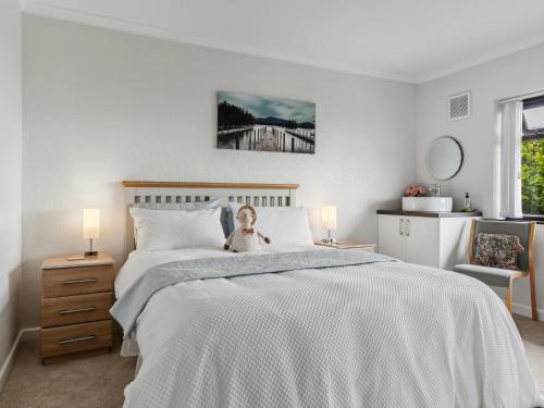 a bedroom with a bed with a teddy bear sitting on it at Kents Bank Holiday - Pet Friendly with Bay Views in Grange Over Sands