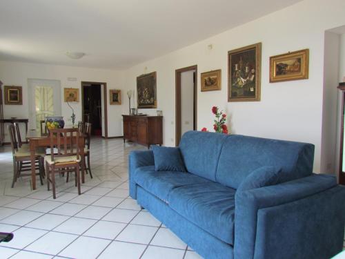 a living room with a blue couch and a dining room at Casa De Angelis in Erchie