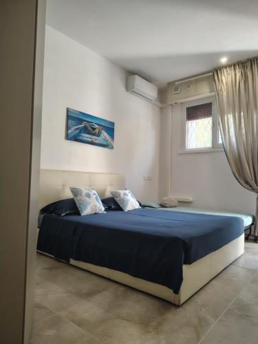 a bedroom with a large bed with blue sheets at SEA Studio Flat in Misano Adriatico