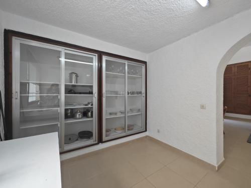 an empty room with a large glass cabinet with dishes at Villa Serra Brava mt Gemeinschatspool, 3 Apartments in Lloret de Mar