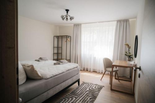 a bedroom with a bed and a table with a chair at Fewo-Welz in Bad Kissingen