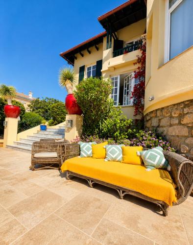 a yellow couch sitting outside of a house at La Garoupe-Gardiole Boutique Hotel in Antibes