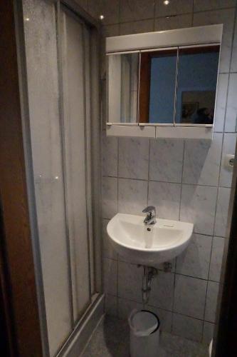a white bathroom with a sink and a shower at Haus Alpenblick inkl. Chiemgaukarte in Ruhpolding