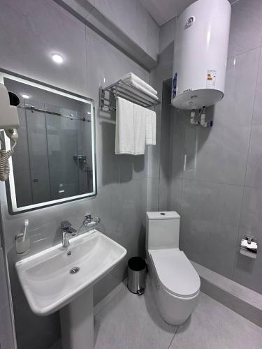 a bathroom with a sink and a toilet and a mirror at Grand Silk Road in Samarkand