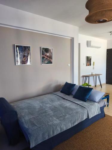 a bedroom with a bed with blue pillows at Michelle Mediterranean Suites in Meneou