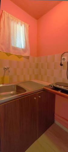 a small kitchen with a sink and a window at Revival rooms in Nikiana