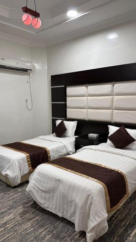 a hotel room with two beds with white and brown sheets at شقق ركن التاسيس in Najran