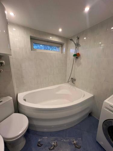 a white bathroom with a tub and a toilet at Tähe majutus in Mustvee