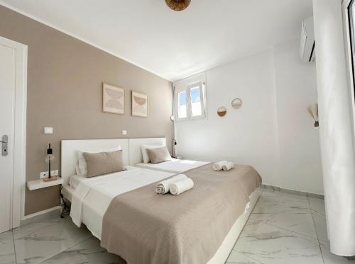 a white bedroom with two beds with towels on them at Lilu Villa 1 with Private Pool and Seaview in Tigaki