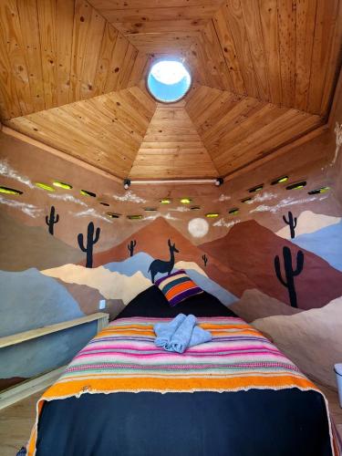 a room with a bed with a painting on the ceiling at Casa Voyage Hostel in San Pedro de Atacama