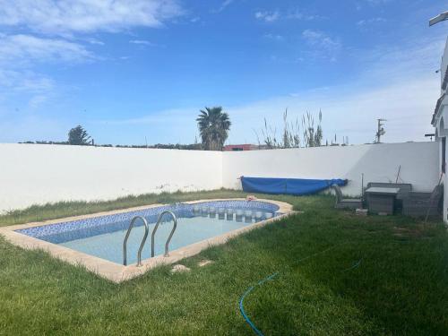 a swimming pool with two metal statues in a yard at Villa Bingo & Piscine in El Jadida