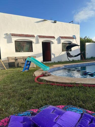 a backyard with a swimming pool and a house at Villa Bingo & Piscine in El Jadida
