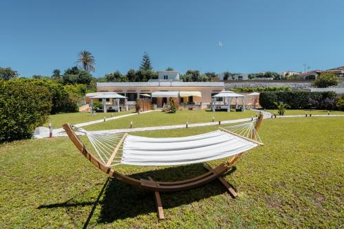 a hammock in the grass in front of a house at Mammacaterina - Procida in Procida