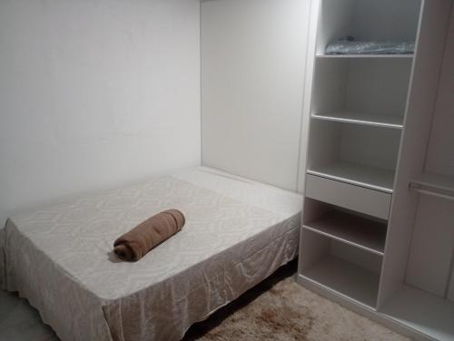 a wooden roll on a bed next to a closet at Quarto privado simples para o público masculino em acomodação compartilhada in Serra