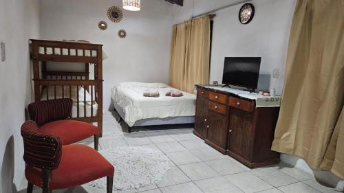 a bedroom with a bed and a television and a chair at Bell Ville in Bell Ville