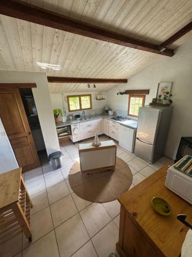 a large kitchen with white appliances and a wooden ceiling at Gîte de Rille in Castelnau-Durban