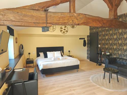 a bedroom with a bed and a couch at À L'AISE - Chambres d'hôtes à Vianne in Vianne