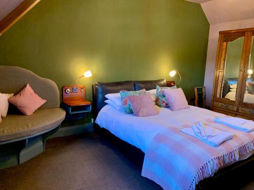 a bedroom with two beds and a chair and a mirror at The Teesdale Hotel in Middleton in Teesdale