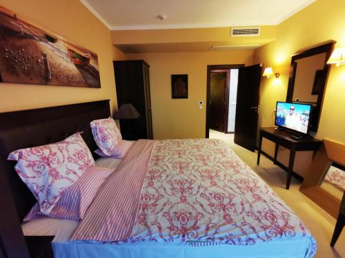 a bedroom with a bed and a television in it at Royal Beach Premium Residence- Sunny Beach in Sunny Beach