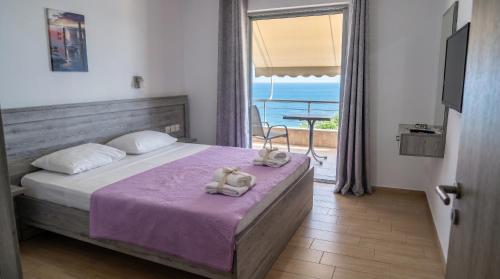 a bedroom with a bed with two teddy bears on it at Blue Sea Apartments in Qeparo