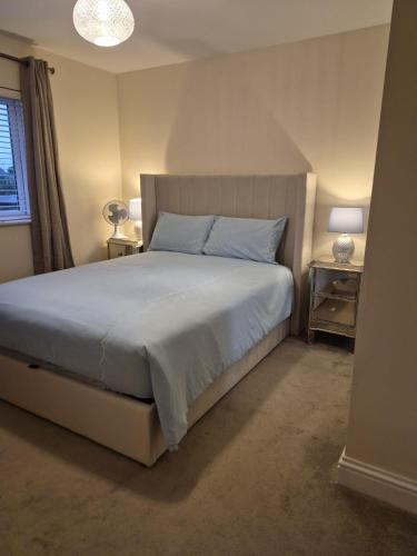 a bedroom with a bed and two lamps and a window at Cozy 2BR apartment in Maidenhead Sleeps 6 in Maidenhead