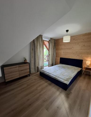 a bedroom with a bed and a wooden floor at Zacisze Wilcza in Zarzecze