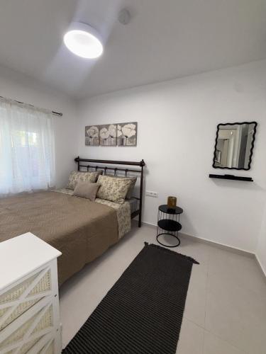 a bedroom with a bed and a tv on the wall at Katsaras Sunset & Pool House in Kremasti