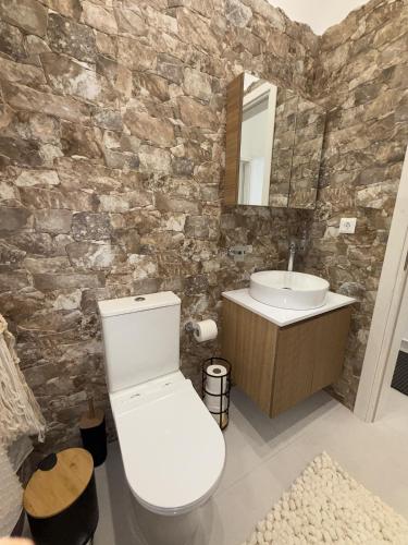 a bathroom with a white toilet and a sink at Katsaras Sunset & Pool House in Kremasti