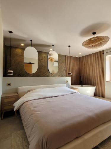 a bedroom with a large bed and a bath tub at L'Écrin de Nature Panoramic View & Prestige in Saint-Marcel-lès-Annonay