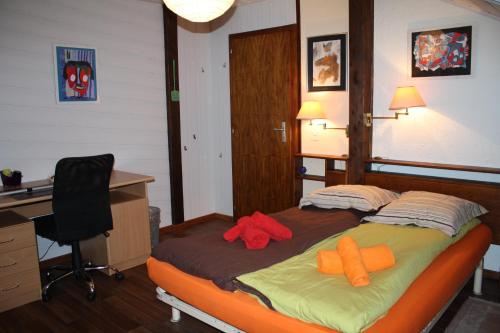 a bedroom with a bed with two orange pillows on it at Appartement 3 chambres dans un chalet in Granges