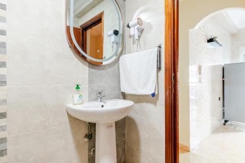 a bathroom with a sink and a mirror at Eden Appartement avec Piscine Et Salle de Sport in El Jadida