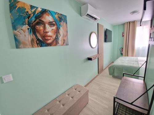 a room with a painting of a woman on the wall at Al Mar pensión in Alicante