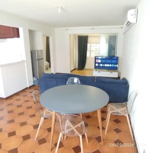 a living room with a blue couch and a table and chairs at Tikanel in Schœlcher