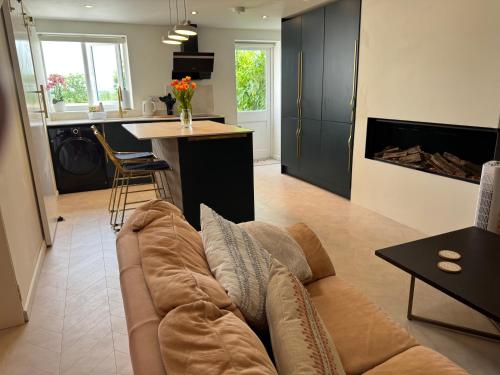 a living room with a couch and a kitchen at Little Rozel in East Grinstead