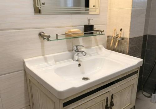 a bathroom sink with a glass shelf above it at Amsy hotel in Dakar