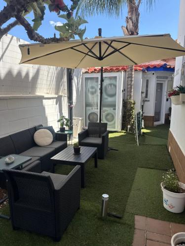 a patio with a table and an umbrella at Mex-Goretti House in Mairena del Aljarafe