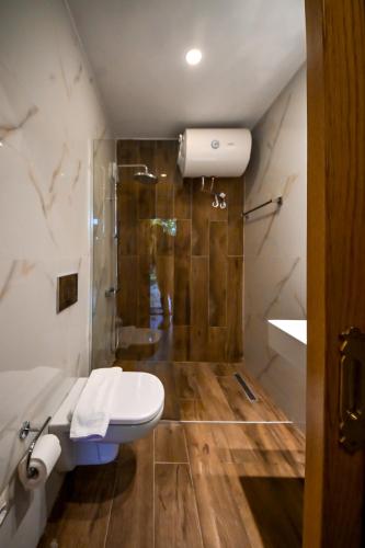 a bathroom with a toilet and a shower at Hotel Gjirokastra in Gjirokastër