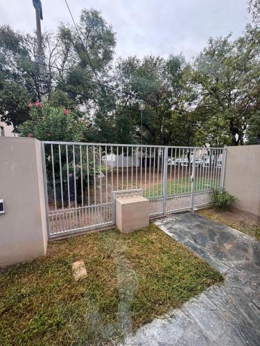 a white fence with a box in the grass at Duplex Los Molles in Santa Rosa