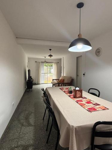 a dining room with a table and a room with a couch at Duplex Los Molles in Santa Rosa