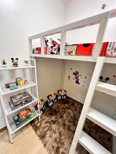 a room with a bunk bed with white shelves at Hope residences 501 building b in Trece Martires