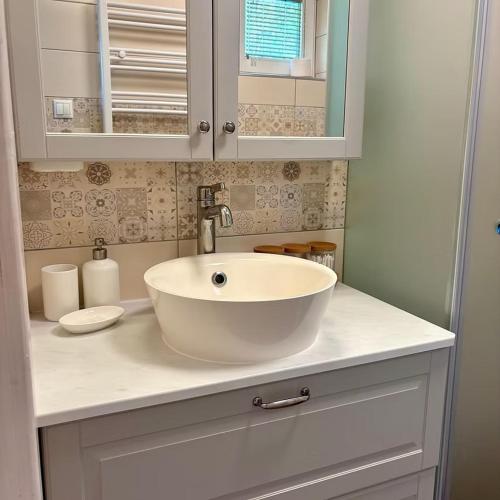 a bathroom with a white sink and a mirror at Villa ZöldFüge in Balatonfůzfő