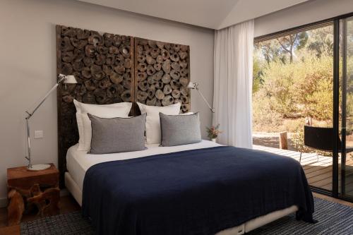 a bedroom with a large bed and a large window at Sublime Comporta in Comporta